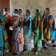 Women wait in line to cast their vote with some deciding to ditch their masks.